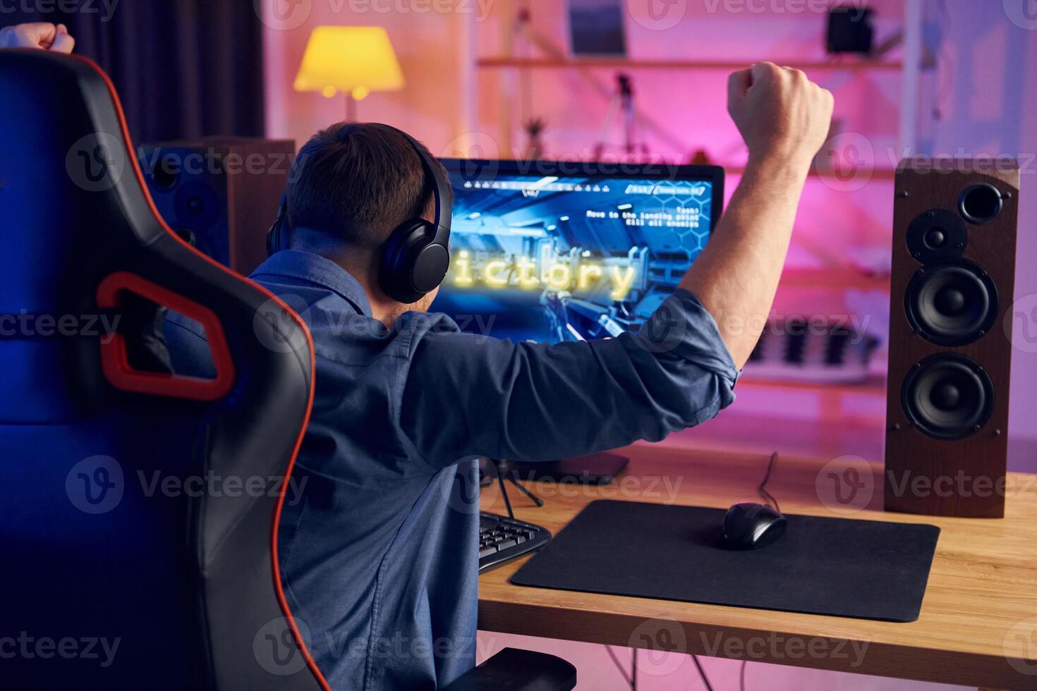 A man sitting at a desk with his arms up photo