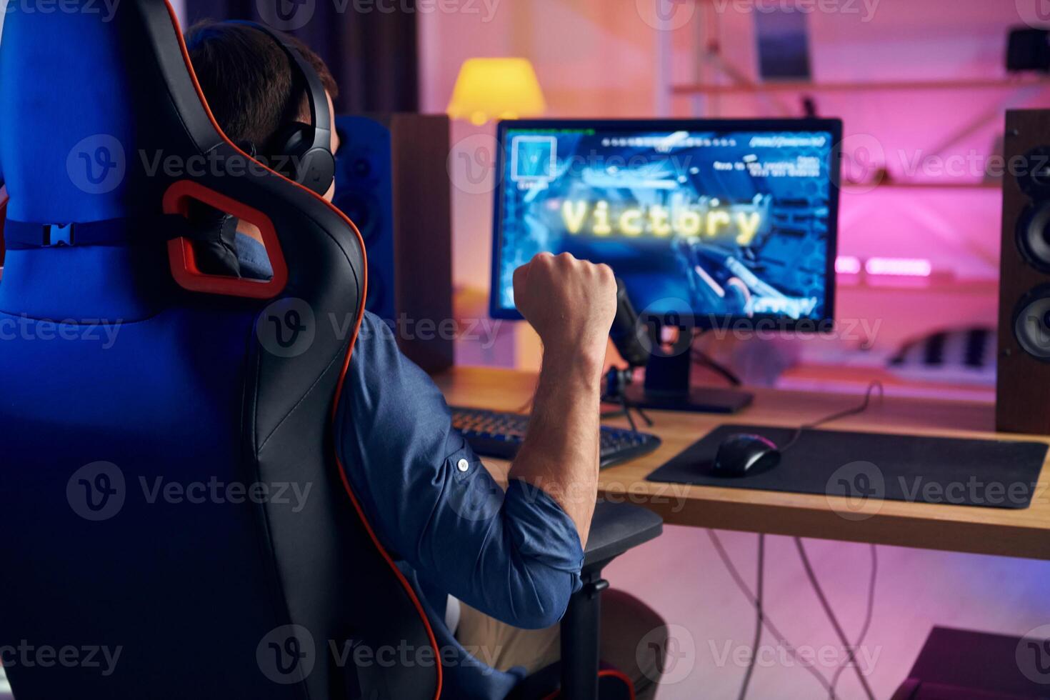 A man is sitting in a chair playing a game photo