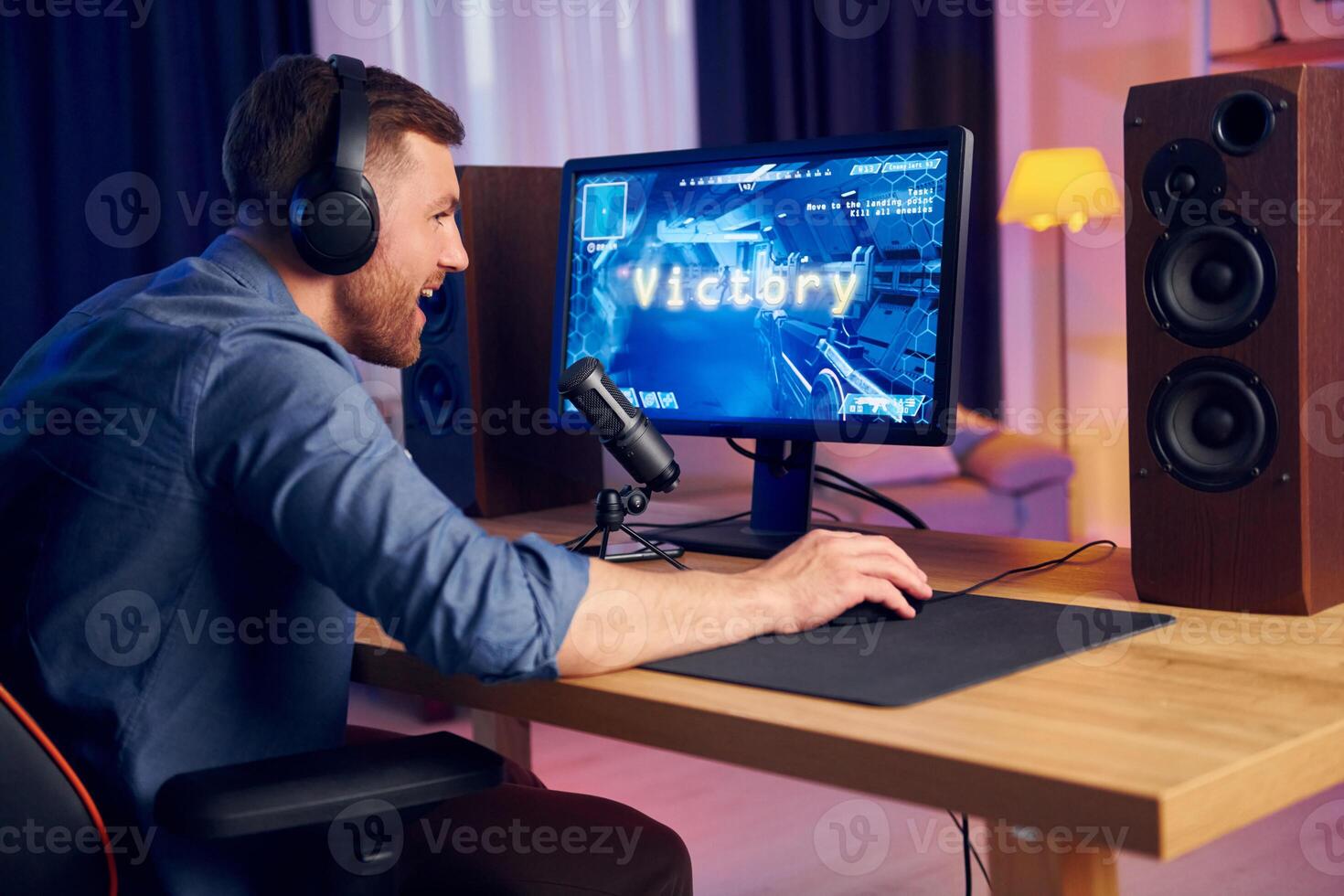 A man wearing headphones is playing games on a computer photo