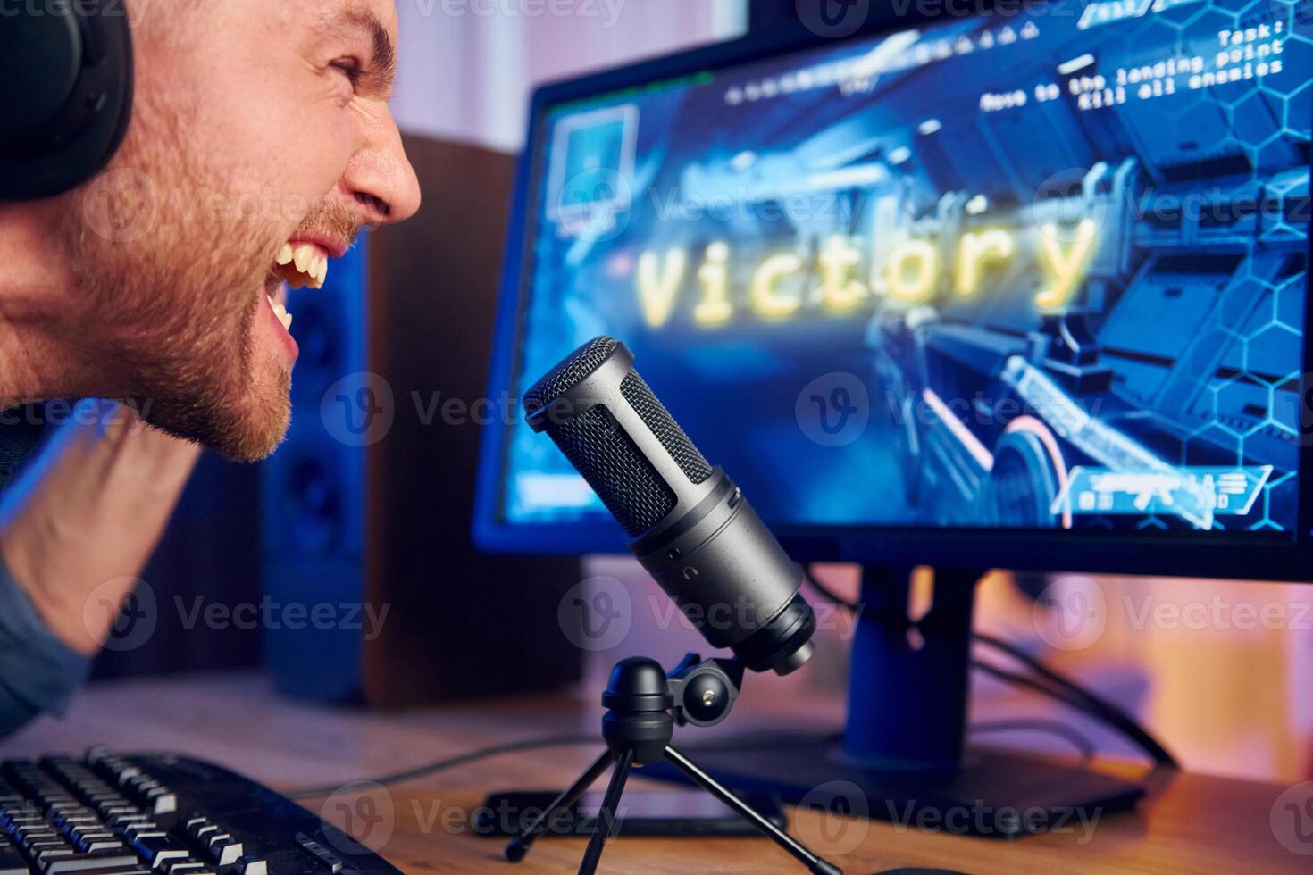 A man is screaming into a microphone while playing games photo