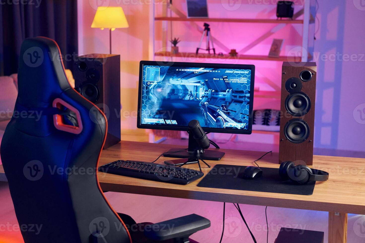 A gaming chair and a computer monitor on a desk photo