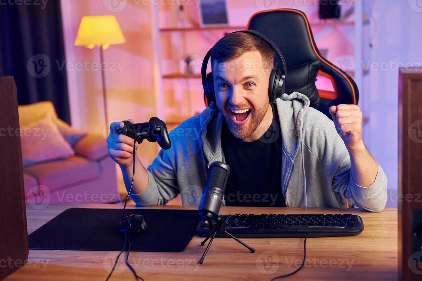 A man with headphones and a controller is playing games photo