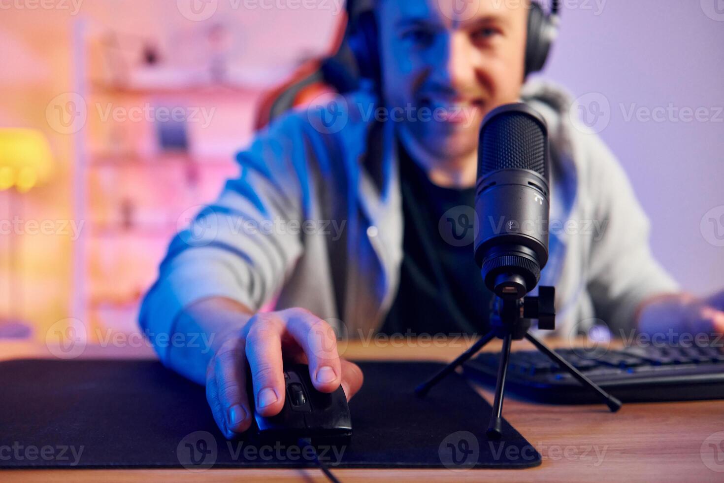 A man is using a microphone and a computer mouse photo