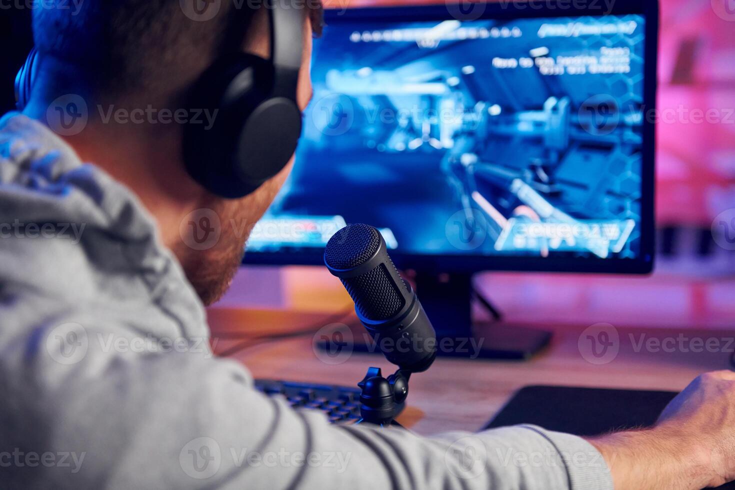 A man wearing headphones is playing a game photo