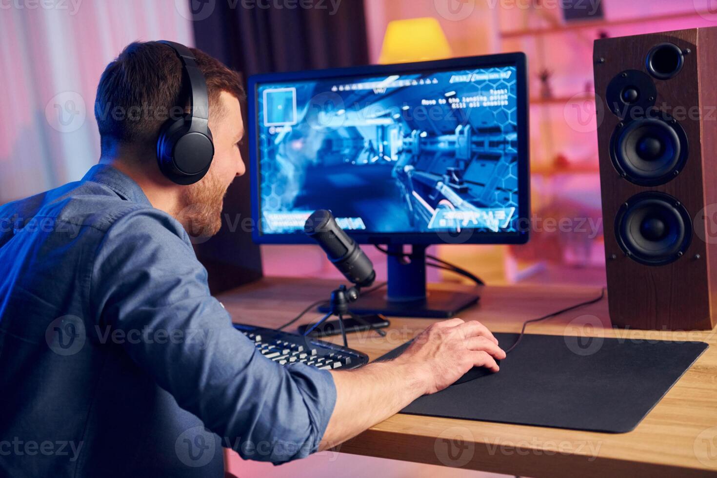 A man wearing headphones is playing a game photo