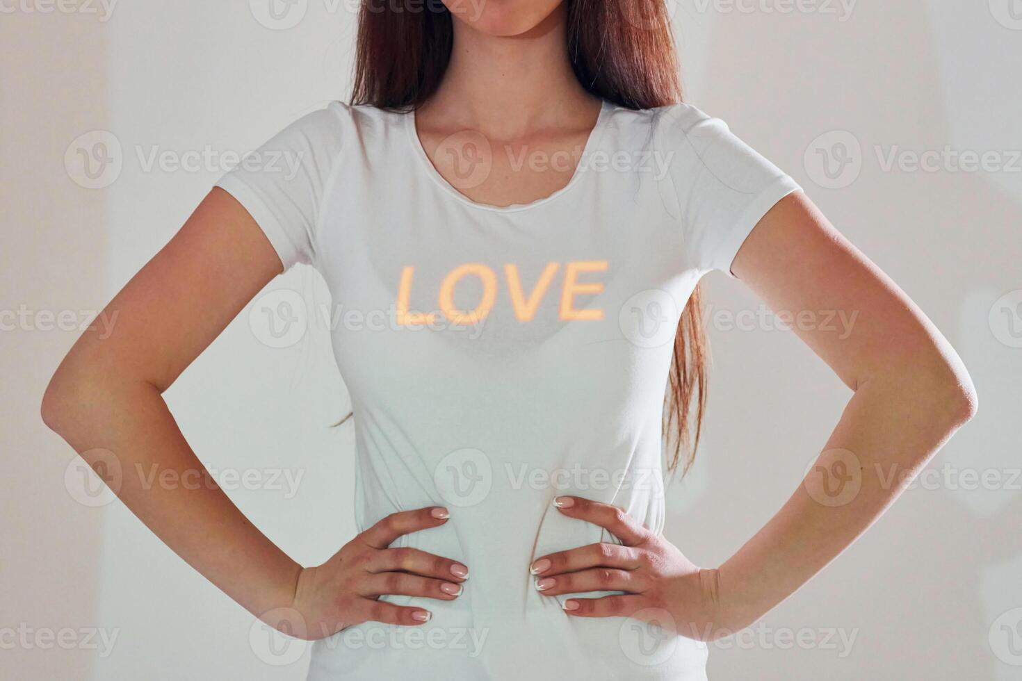 A woman wearing a white t - shirt with the word love on it photo