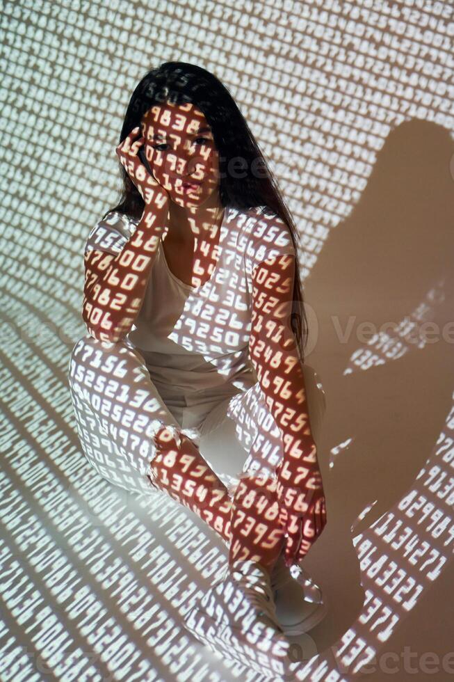 A woman sitting on the floor with her hands on her face photo