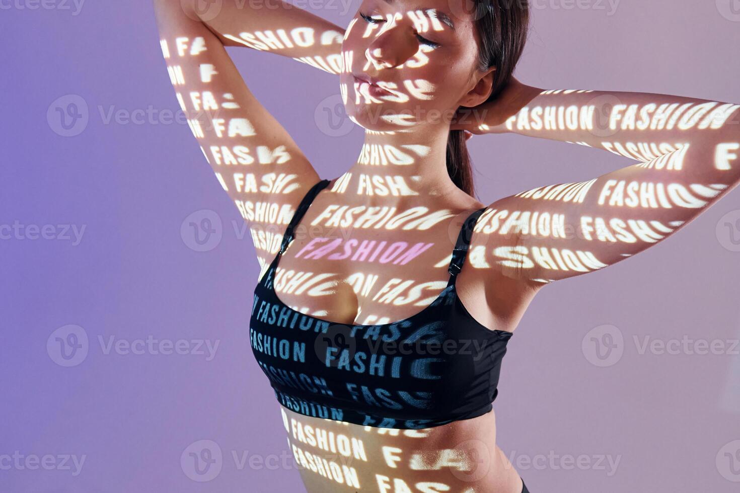 A woman in a sports bra top with words on her body photo