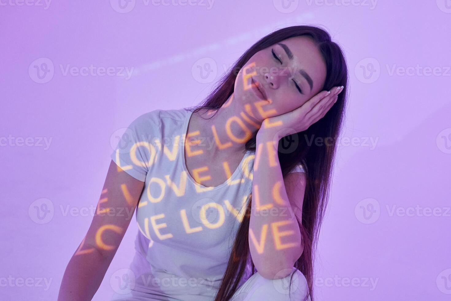 A woman sitting on a white chair with her eyes closed photo