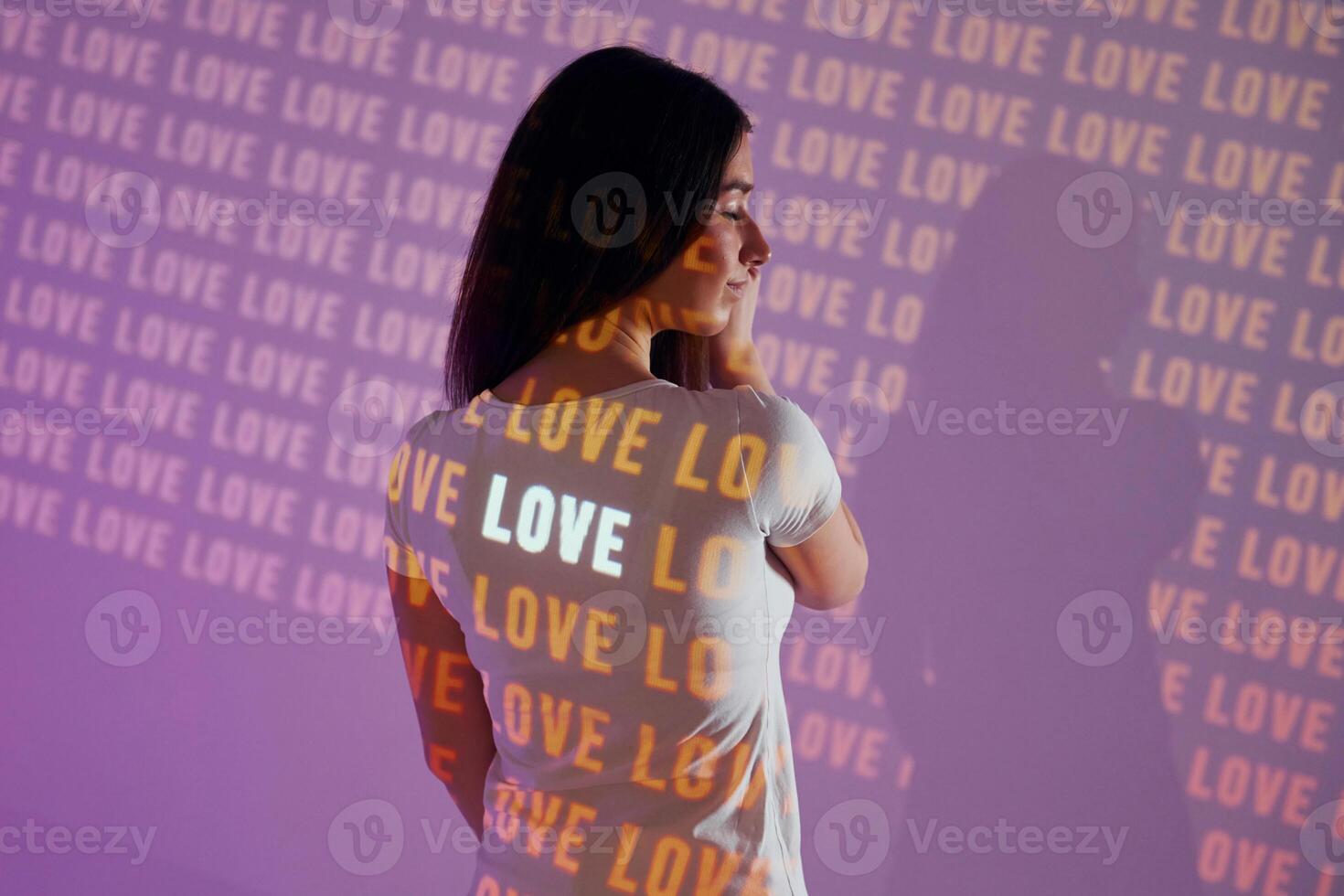 A woman wearing a white t - shirt with the word love written on it photo