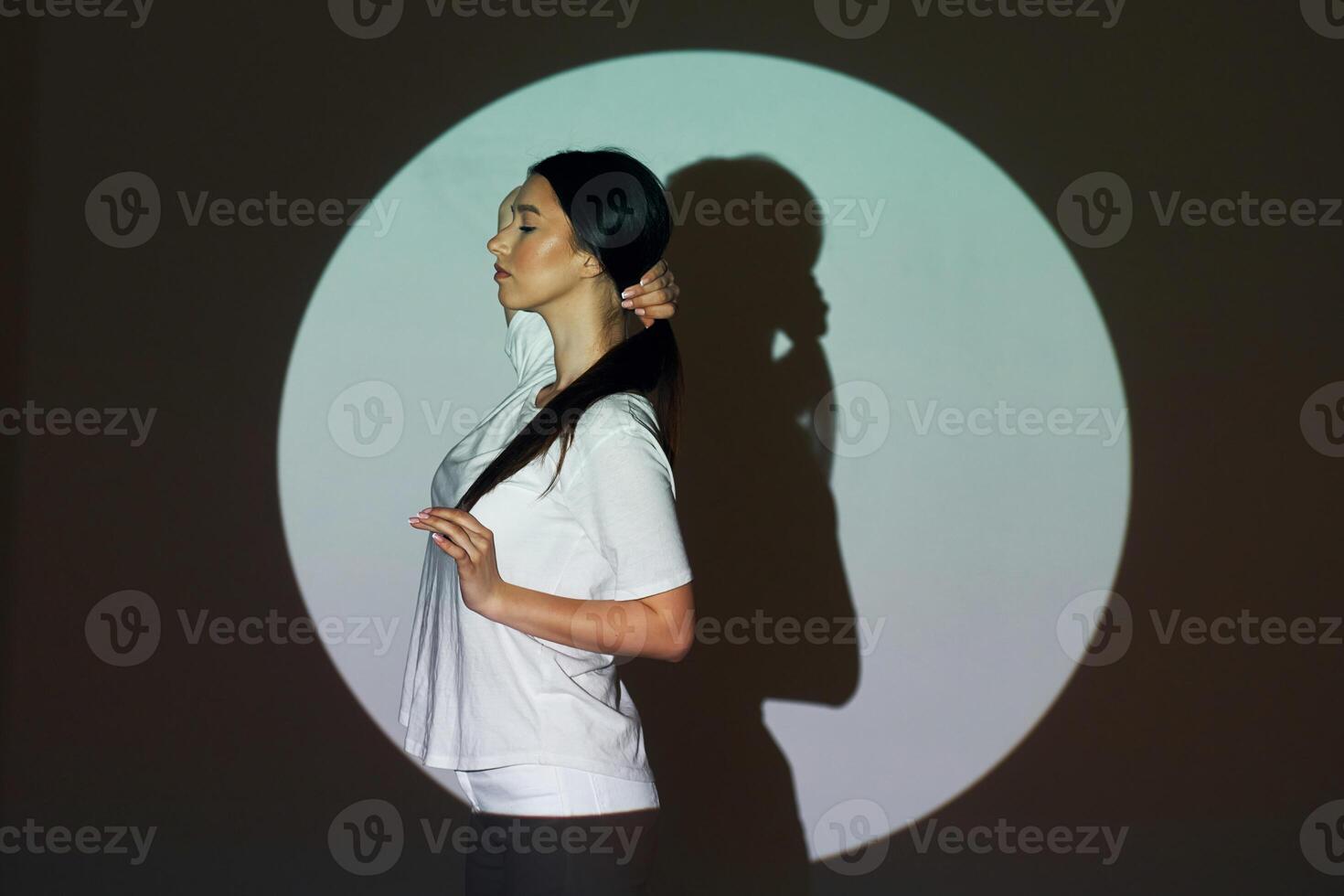 A woman standing in front of a projection of a circle photo