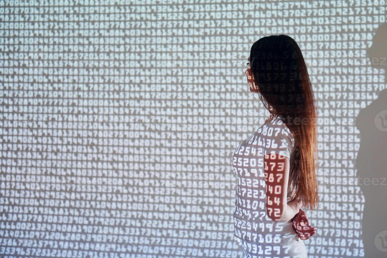 A woman standing in front of a wall with numbers on it photo