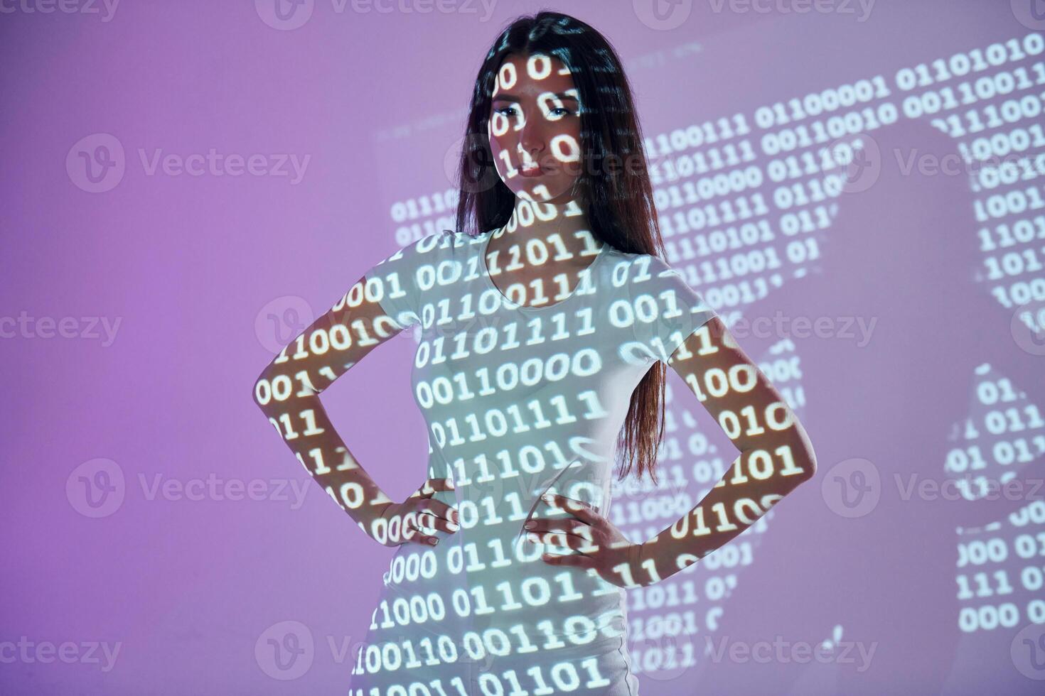 A woman in a white dress is standing in front of a computer screen photo