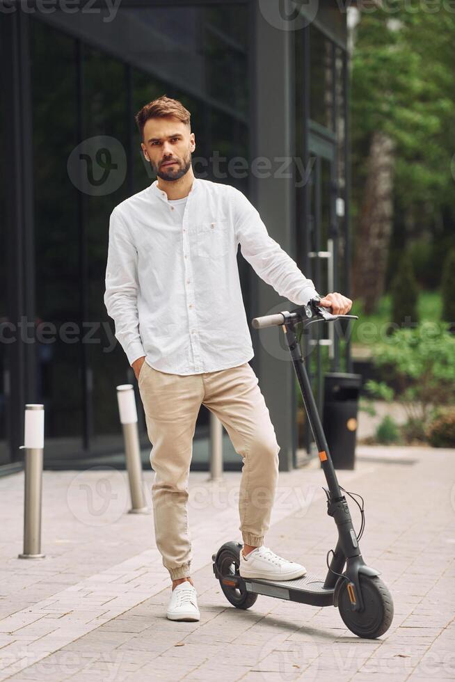 A man is standing on a scooter photo