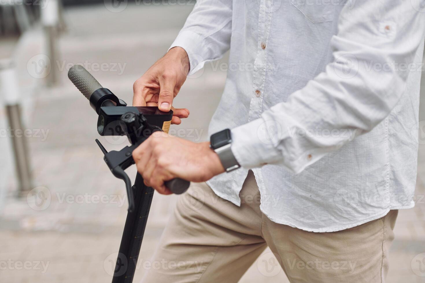 A man is holding onto the handle of a scooter photo