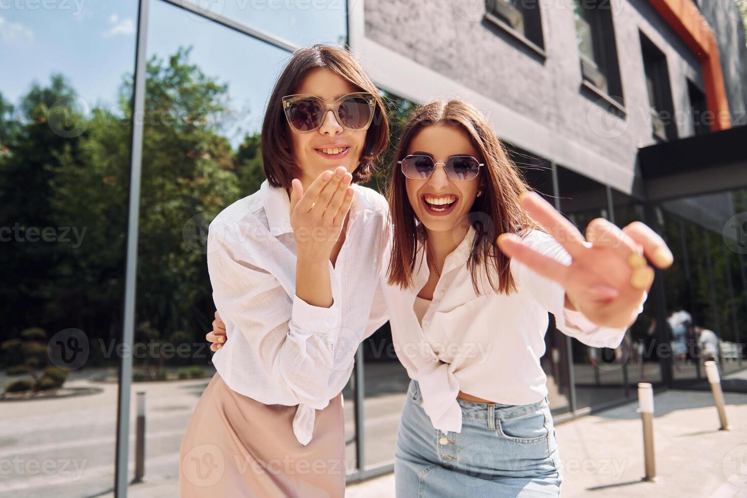 Two young women in sunglasses posing for the camera photo
