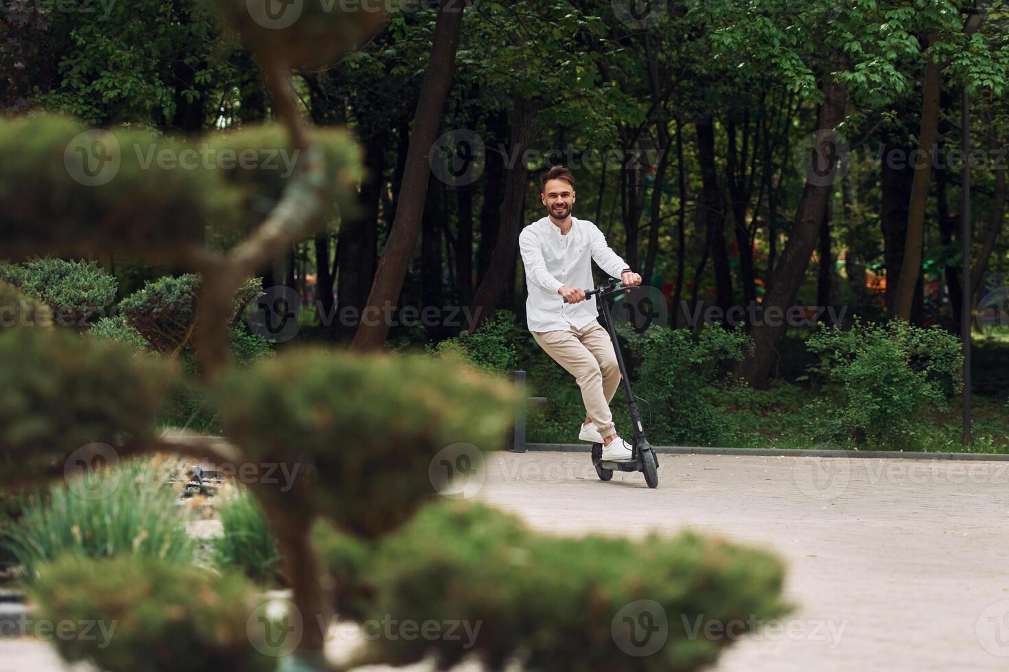 A man riding an electric scooter in a park photo