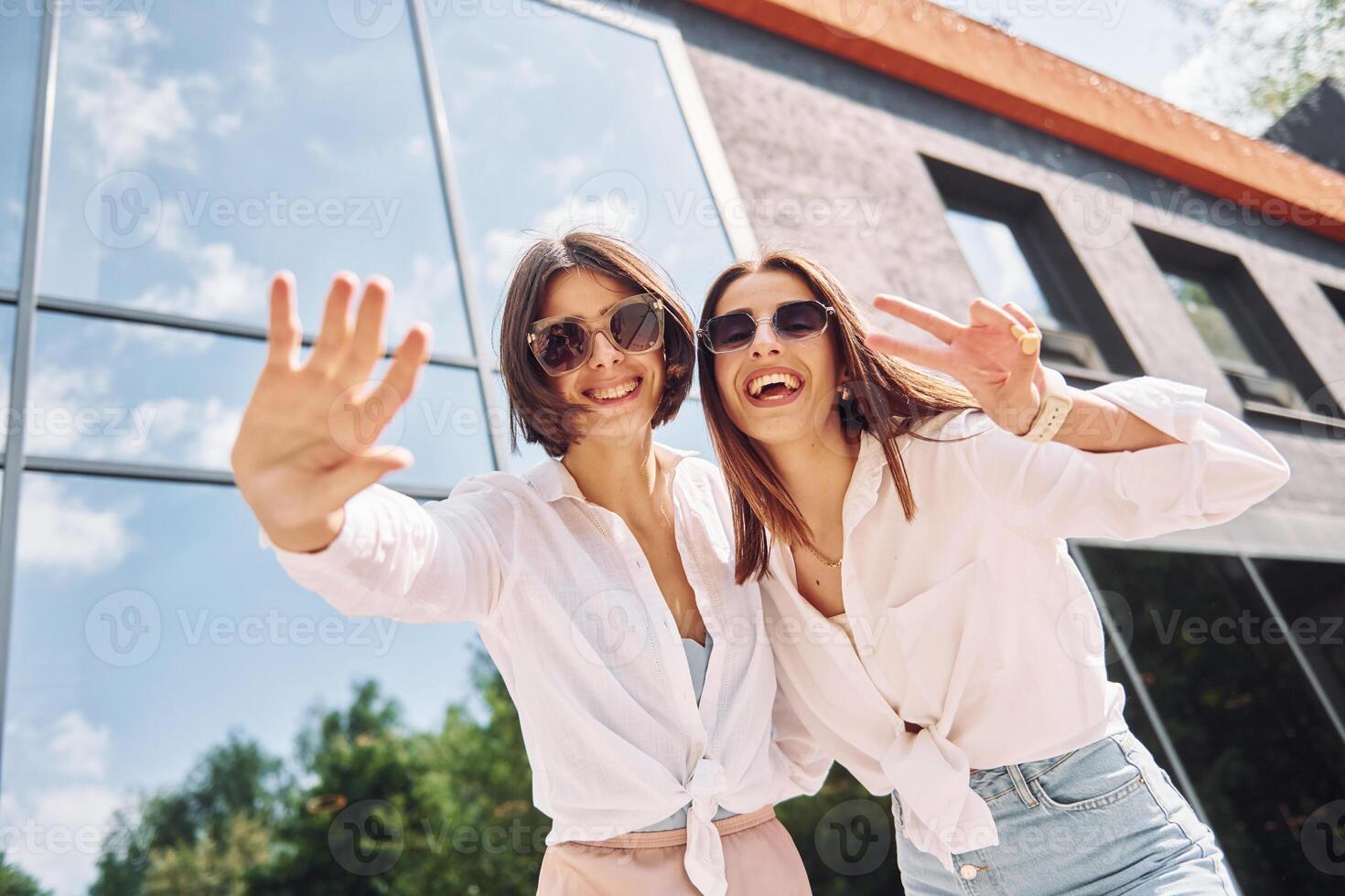 Two women in sunglasses taking a selfie photo