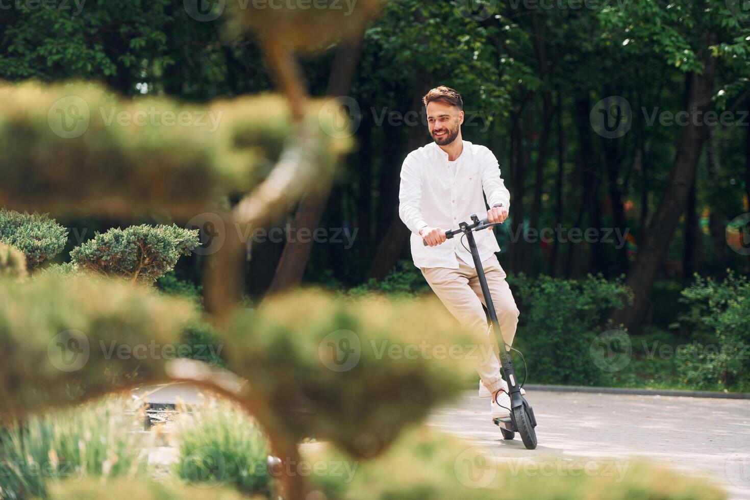 A man riding an electric scooter in a park photo