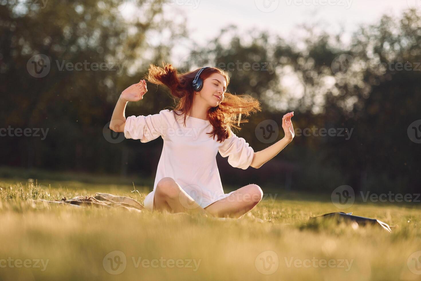 Young girls is enjoying the music. On the field at sunny daytime having nice weekend photo