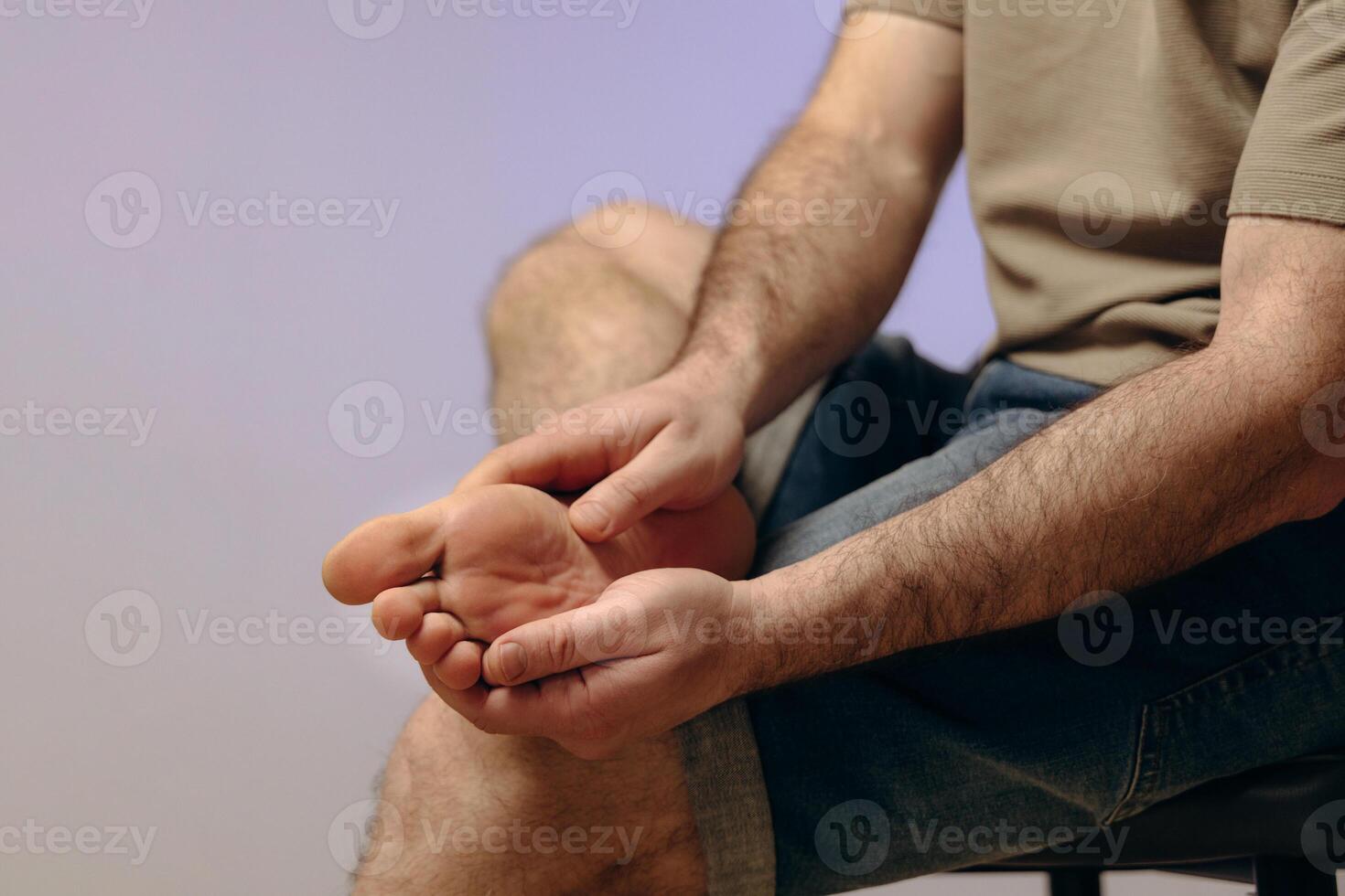 Man holding his leg with his hand, experiencing pain or discomfort. Concept of plantar fasciitis, bruises, stress fractures due to prolonged use, improper footwear or intense training. photo