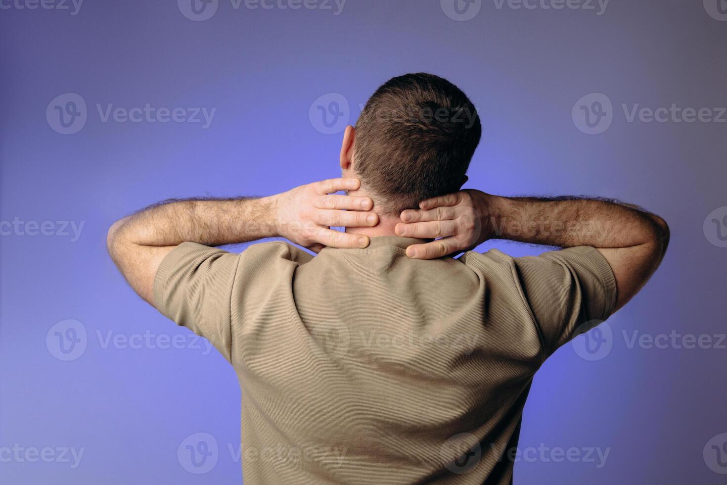 A man experiences back and neck pain due to heavy lifting or sudden movements that can cause strain and injury to the back and neck area. Safe Workout Concept photo