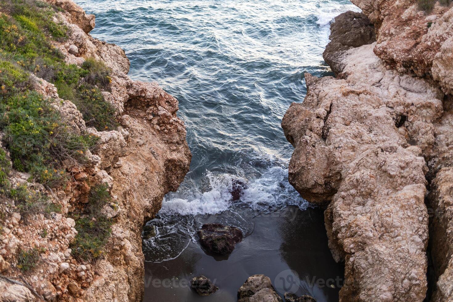 Majestic cliffs on coast of Portugal, washed by the endless ocean in the rays of the sunset. golden light of the sun paints rocks in warm shades, emphasizing their texture and creating long shadows. photo