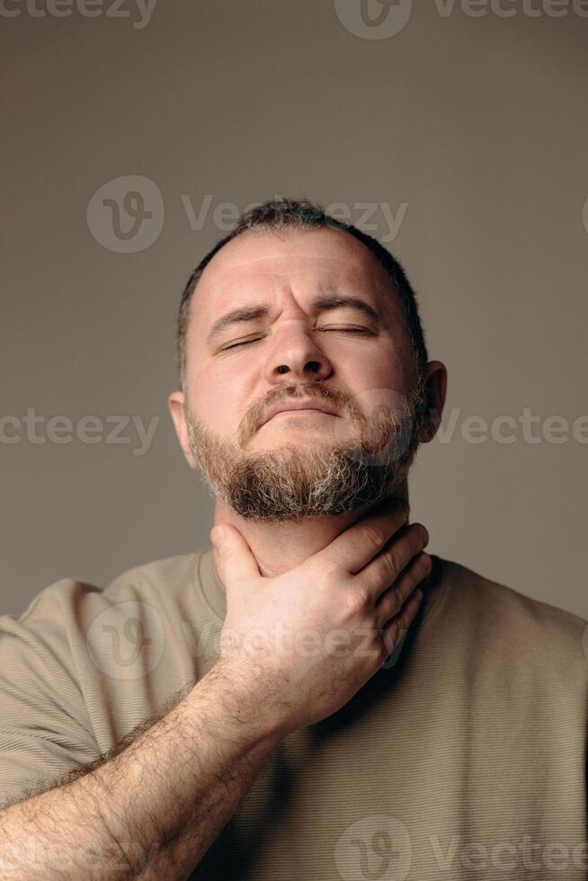 Man suffers from sore throat due to excessive smoking. Electronic cigarettes are harmful to the body and cause painful symptoms. Getting cancer, lung problems. concept of bad habits photo