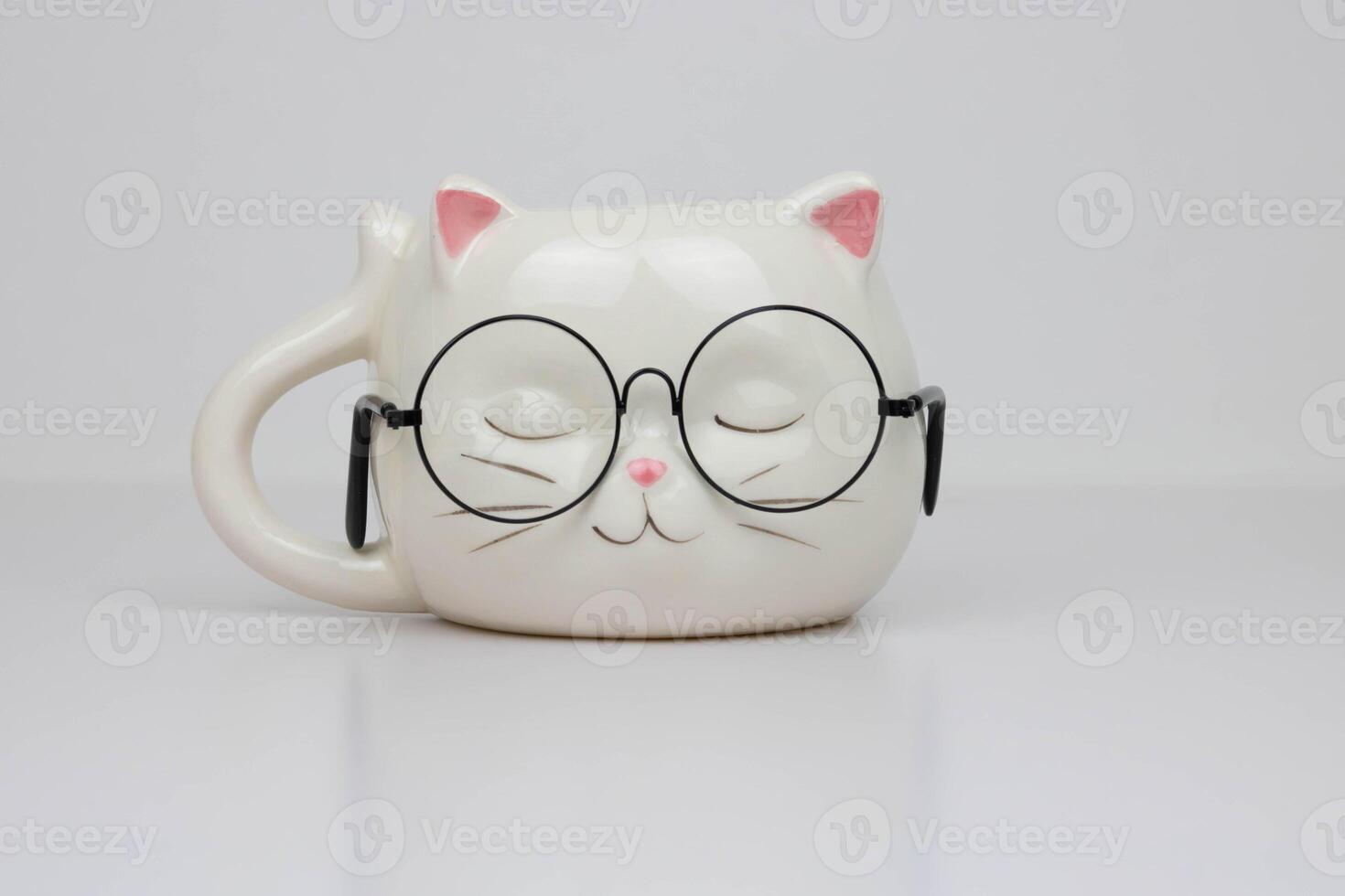 Funny white cup in the shape of a cat's head with round glasses. photo