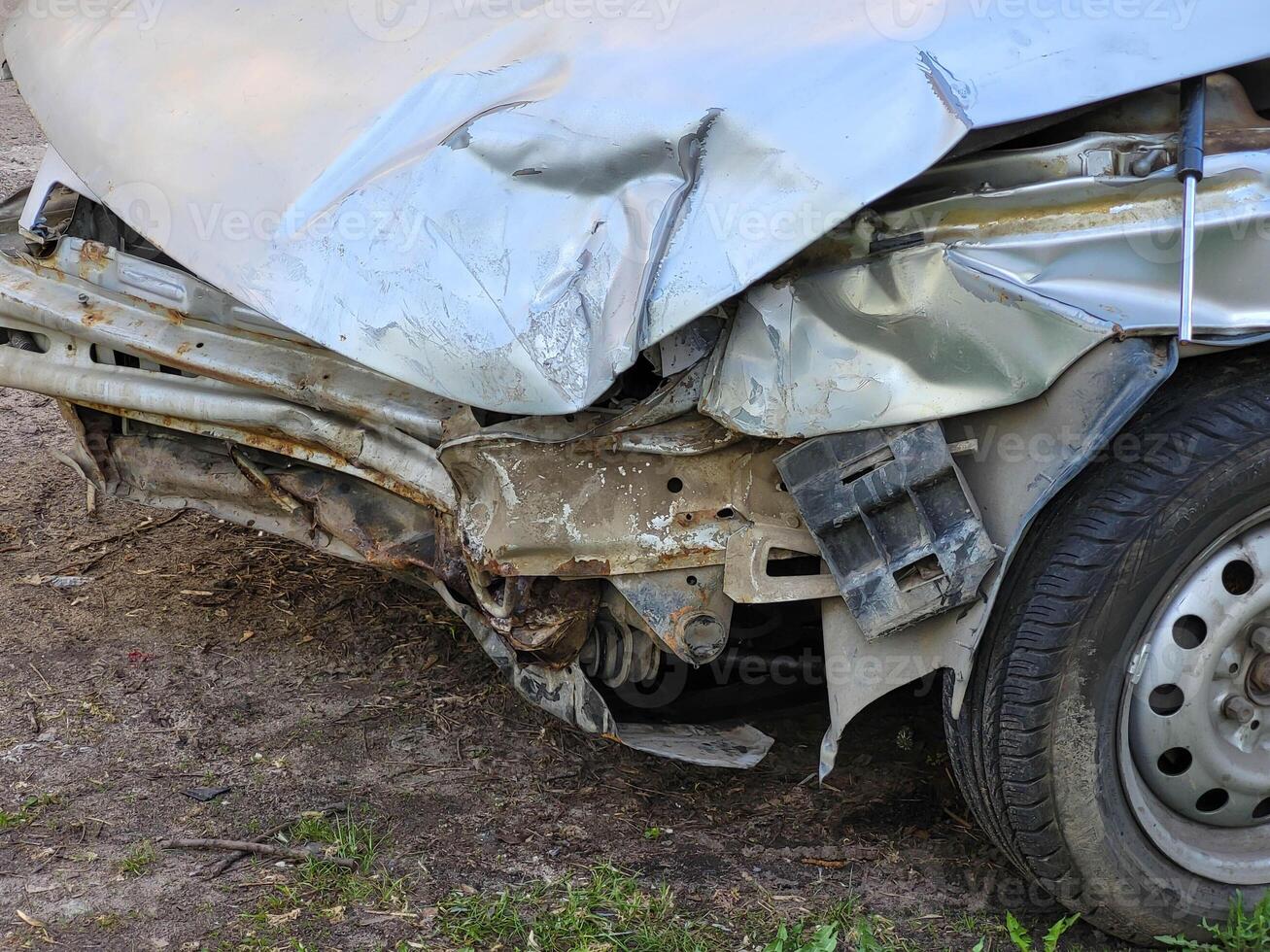 A wrecked car parked on the side of a city road photo
