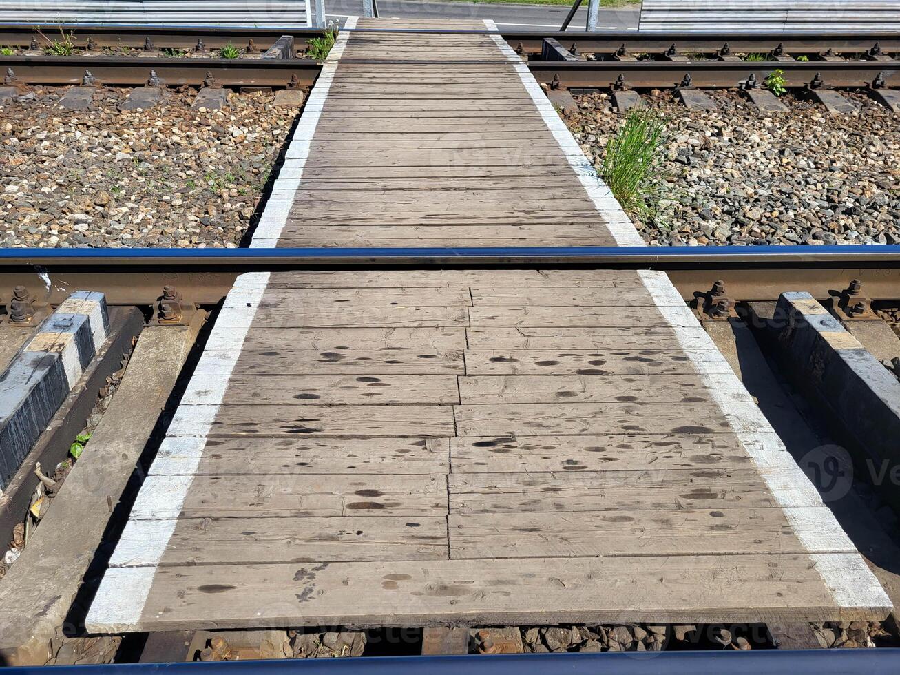 Boardwalk between the rails. Crossing railway tracks. photo