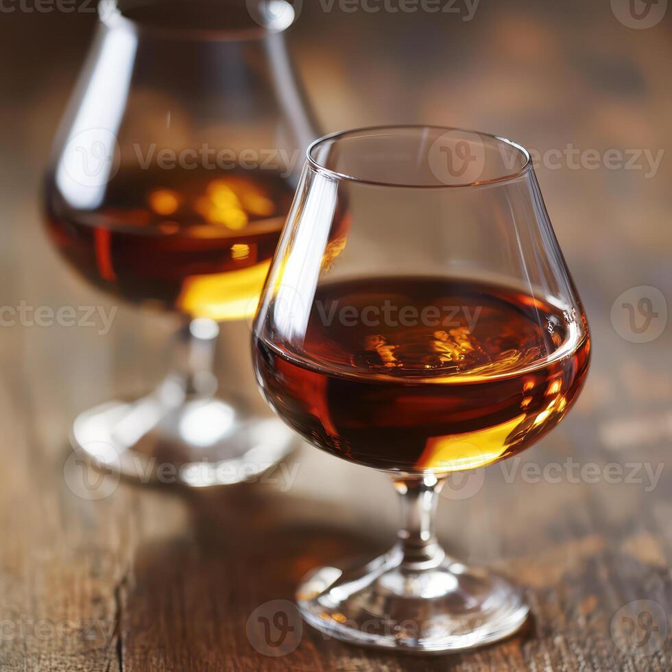 Two glasses of cognac on a wooden table photo