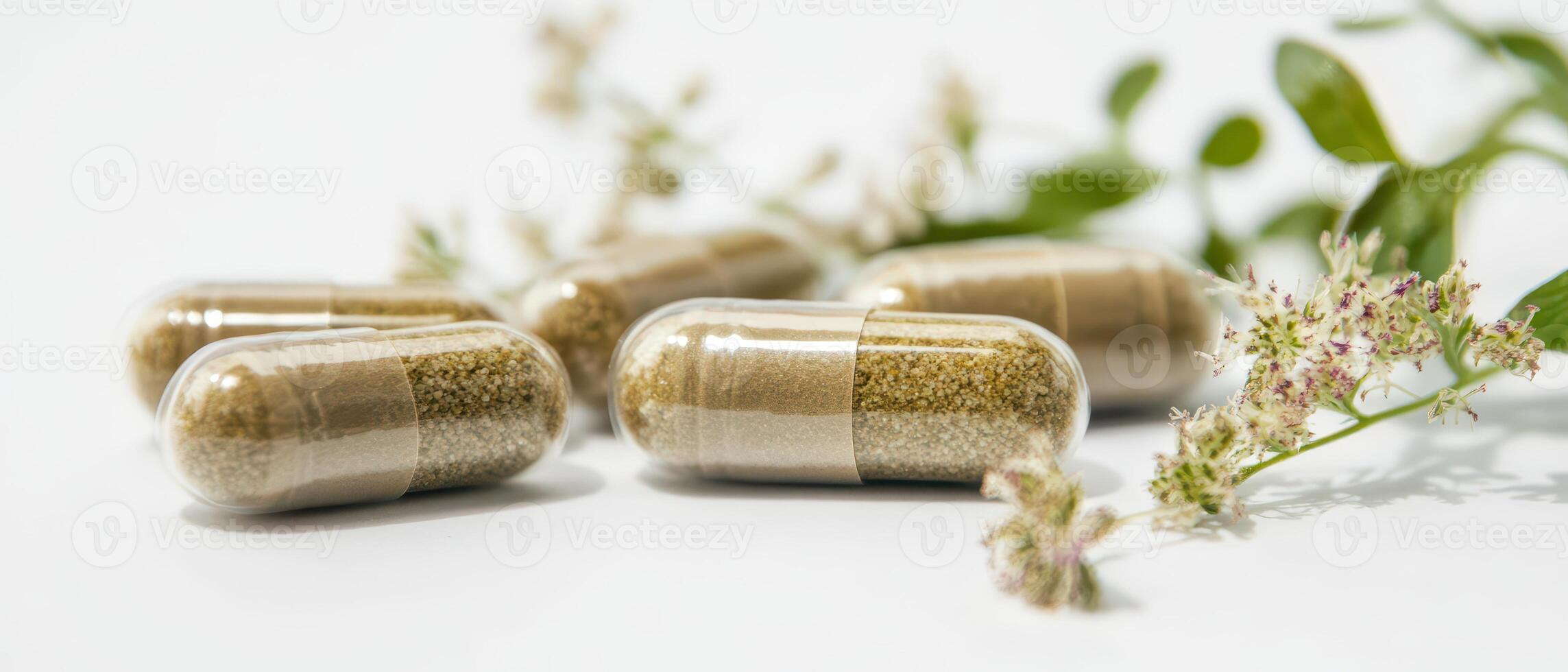 Three capsules with a plant in the background photo