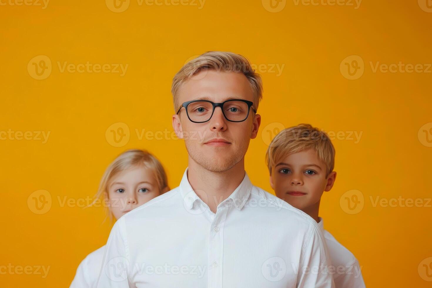 Group portrait of a young man and children with a bright yellow background in a studio setting photo