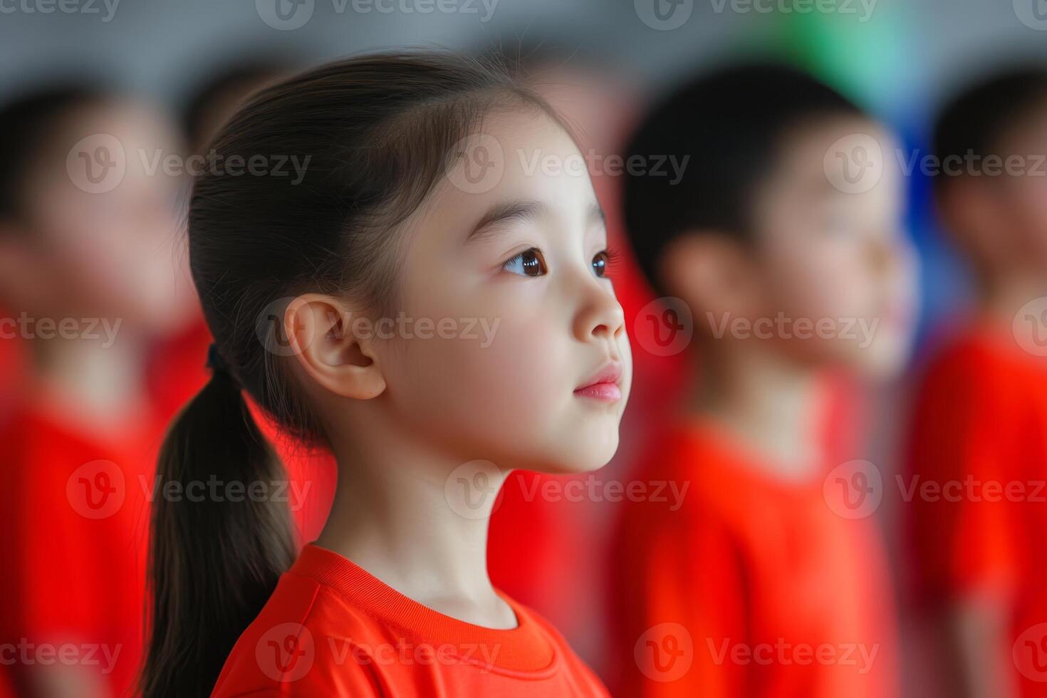 Children in matching red shirts participate in a group activity focused on teamwork and learning at a local community center photo