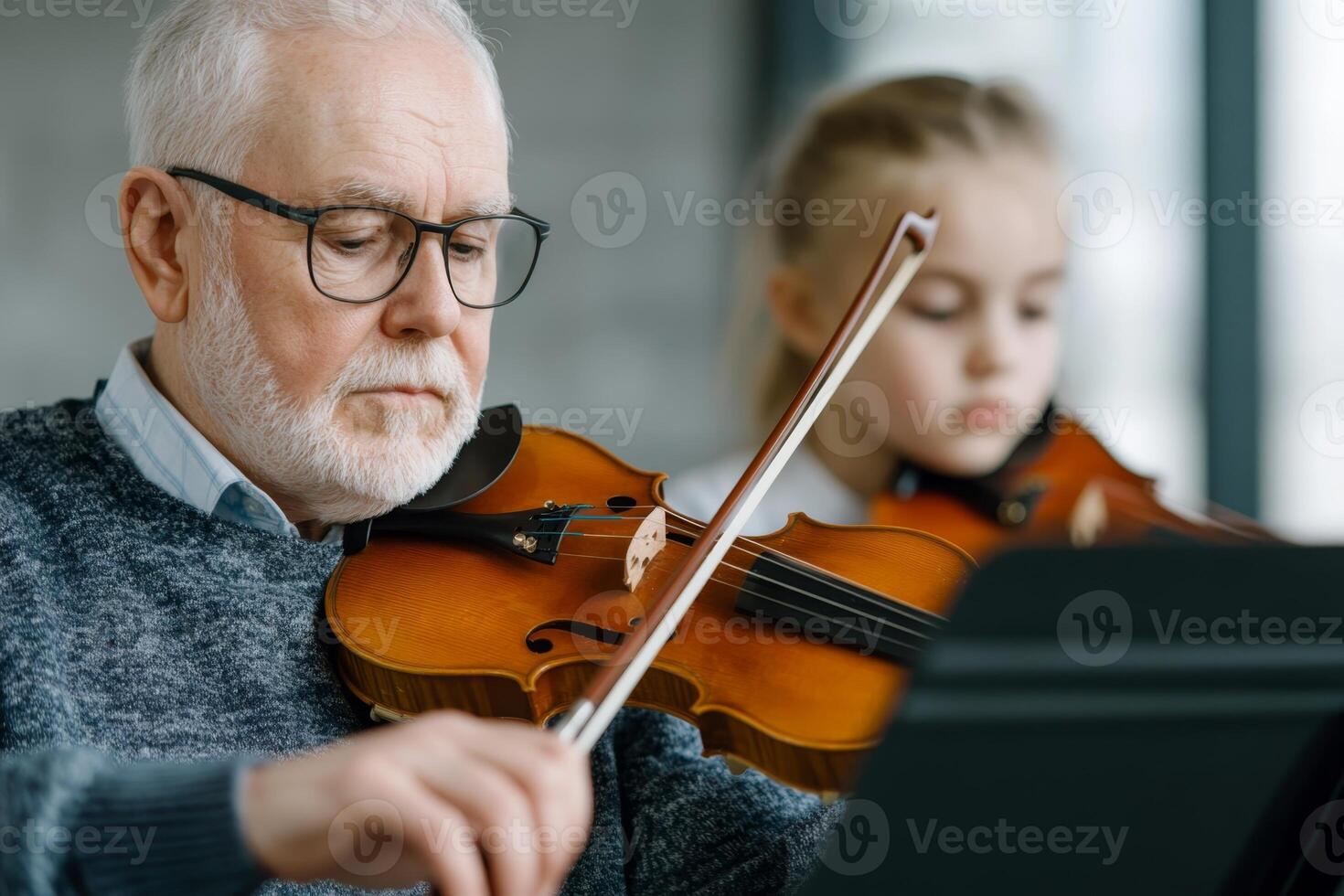 Elderly man and young girl practice violin together in bright indoor space photo