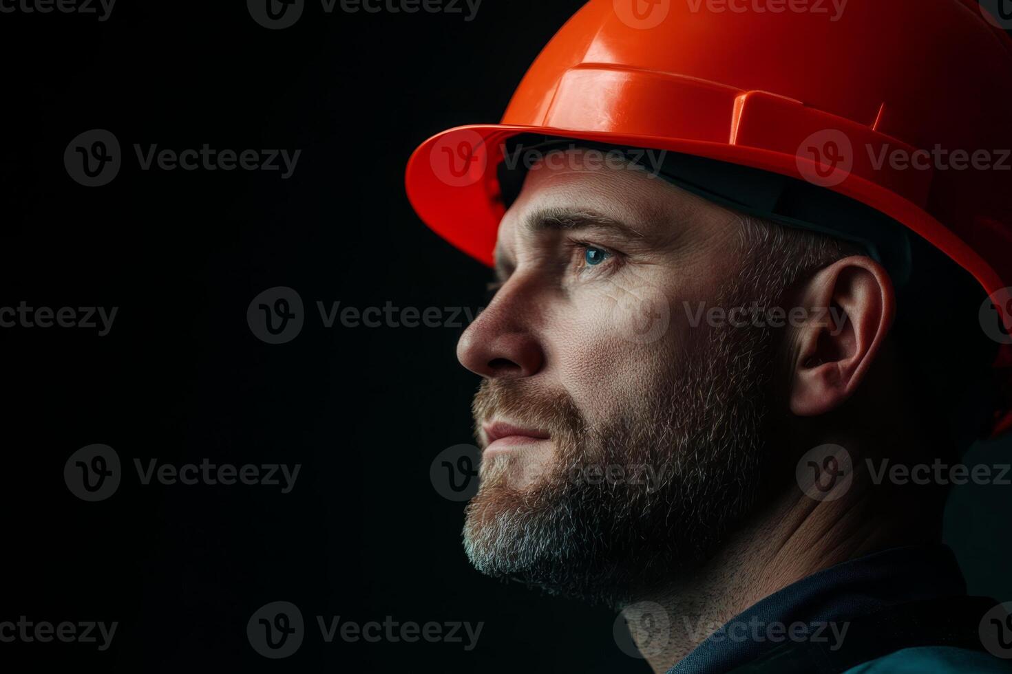 Construction worker in hard hat looking thoughtfully during a safety briefing at a job site in the evening photo