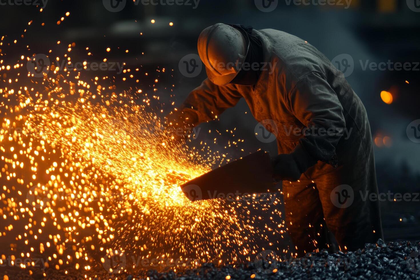 Worker creates sparks while pouring molten metal at an industrial facility during nighttime shift activities photo