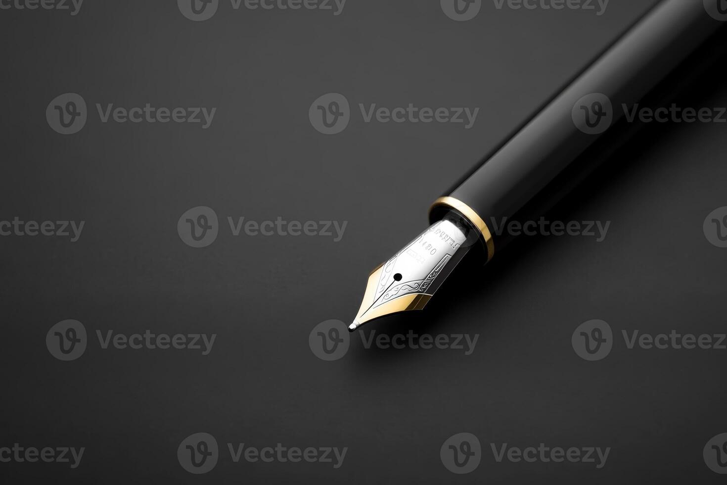 Elegant black fountain pen with a golden nib placed on a dark background in a minimalistic setting photo