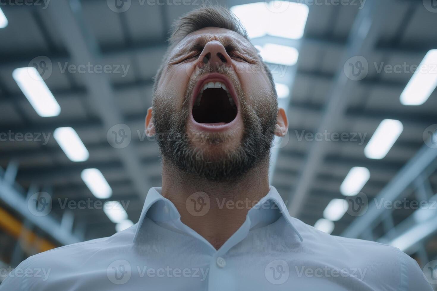 Worker expressing frustration inside a warehouse during busy daytime hours photo