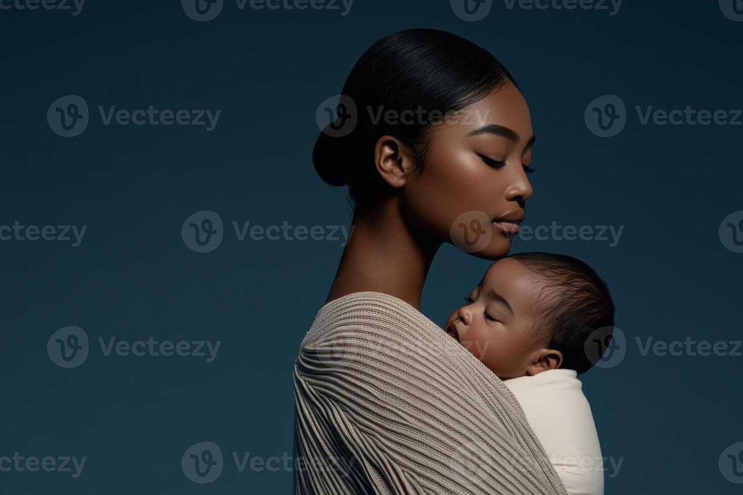 Mother lovingly cradling her sleeping baby against a dark background in a serene moment of connection photo
