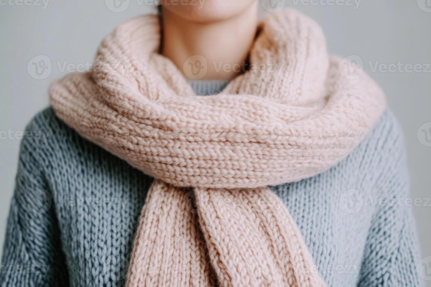 Soft knitted scarf worn on a cozy sweater during a calm indoor setting in autumn season photo