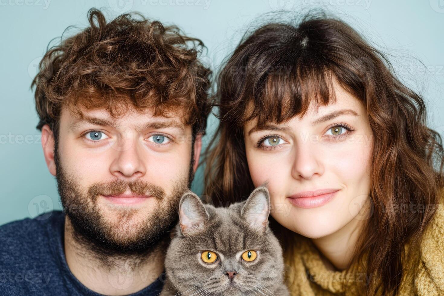 Couple poses with their gray cat in a cozy indoor setting with soft lighting and cheerful expressions photo