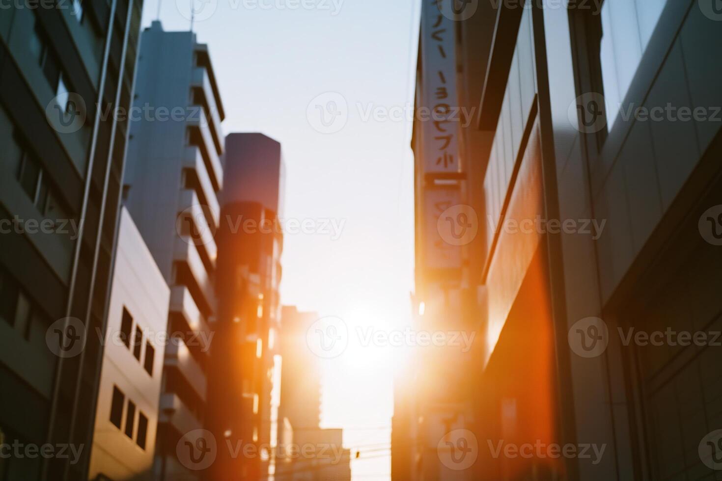 Urban sunset viewed between tall buildings with warm light casting shadows in the late afternoon sky photo