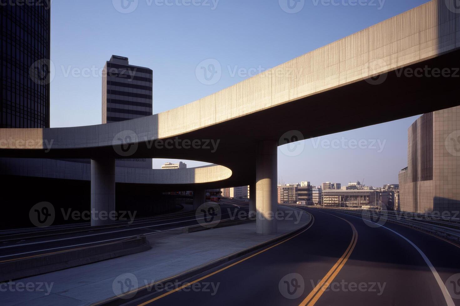 Curved highway interchange with modern buildings under clear blue sky at dusk photo