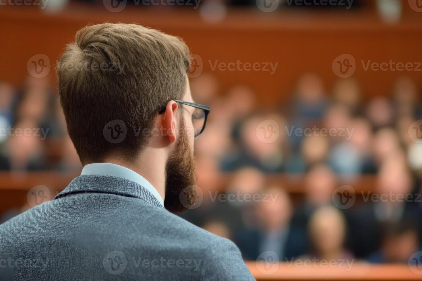Formal presentation by a speaker addressing an audience in a conference setting with focus on engagement and communication photo