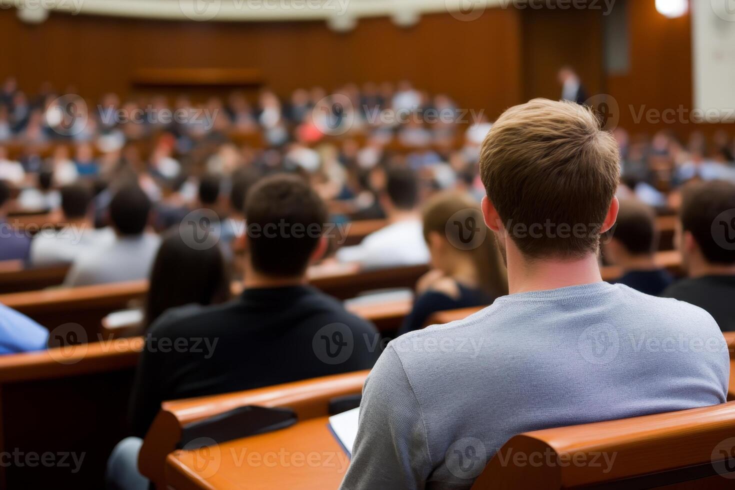 Group of students attending a lecture in a large auditorium during a university class in the afternoon photo