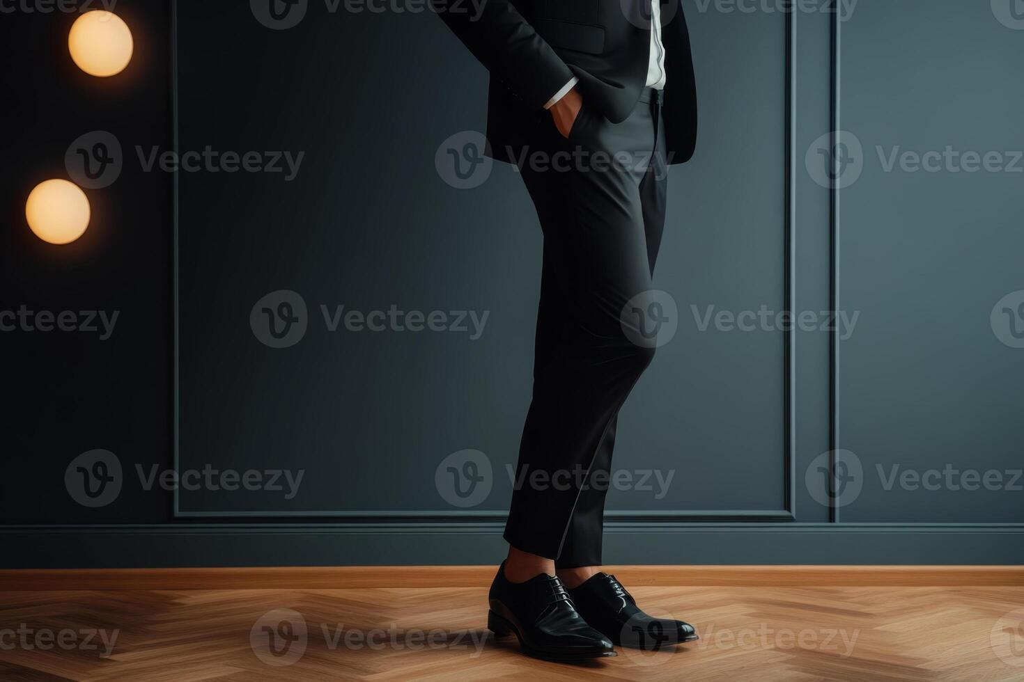Elegant man dressed in formal attire stands confidently against a dark wall in a stylish indoor setting photo