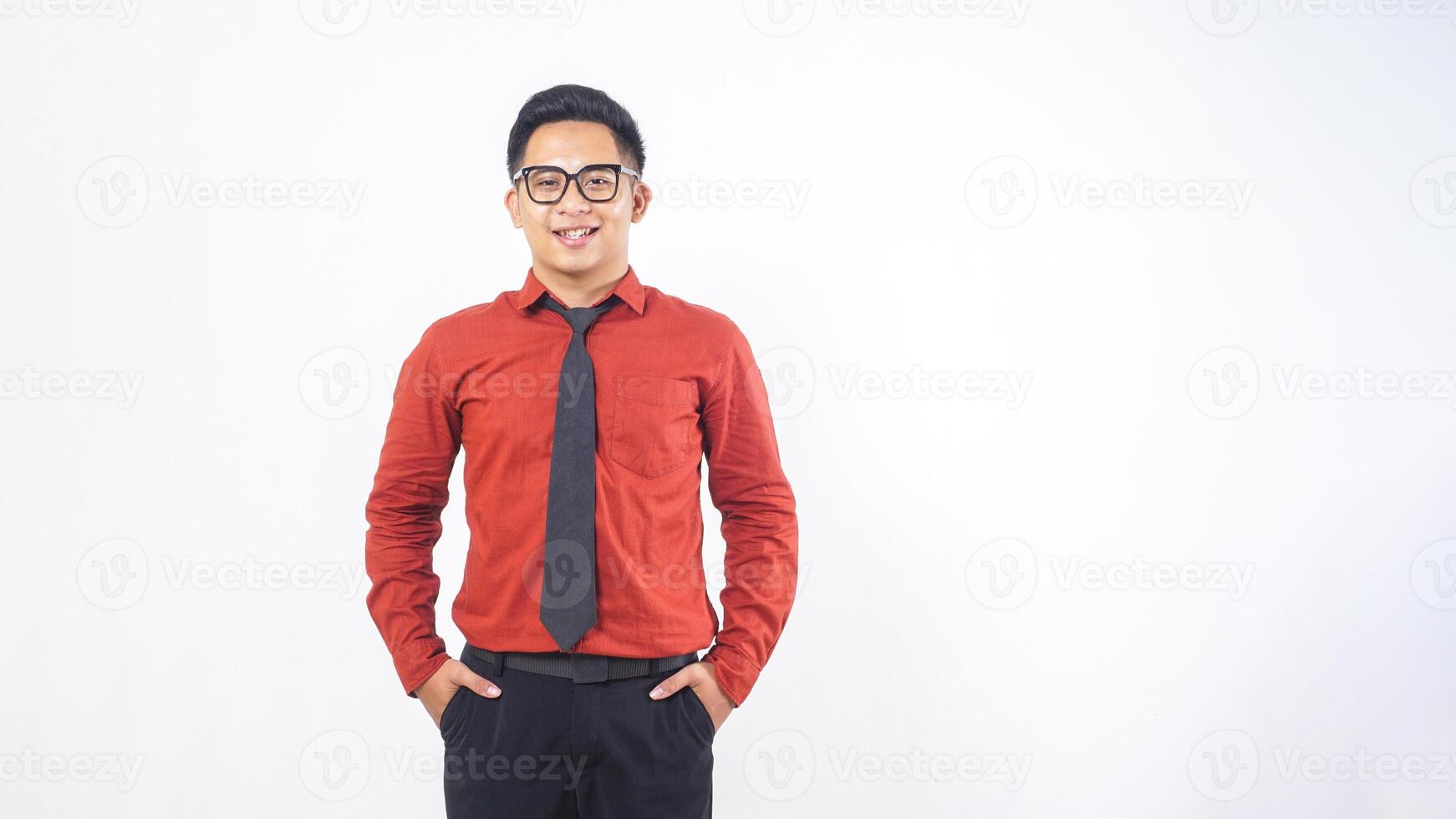Portrait of Smiling Young Adult Asian Man in Terracotta Colored Shirt Standing on White Background photo