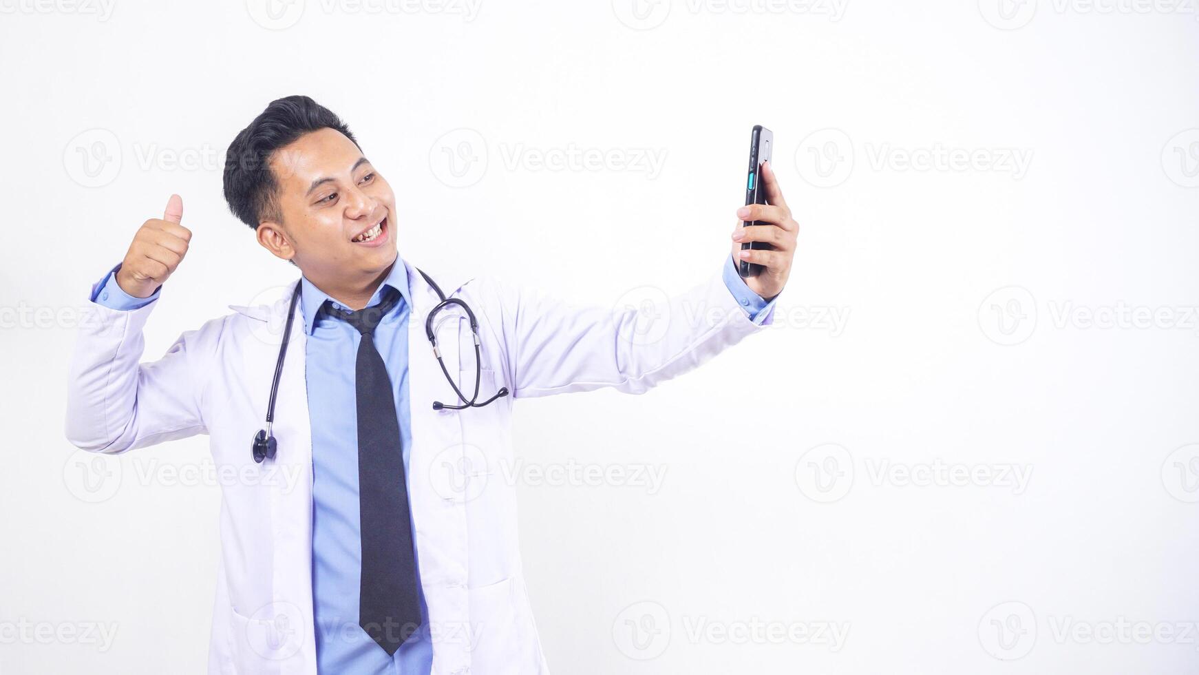 Asian Male Doctor Making Phone Call and Showing Thumb Up on White Doctor photo